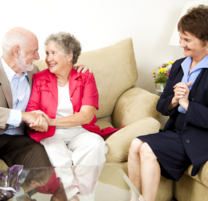 old couple smiling to each other with caregiver happy for them