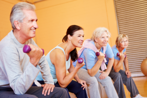 caregiver assisting elderly patients on exercising